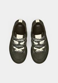 Μαύρα αθλητικά παπούτσια με λευκά κορδόνια και λεπτομέρειες, με λείο ανώτερο υλικό, στρογγυλή μύτη και υφή στην σόλα.