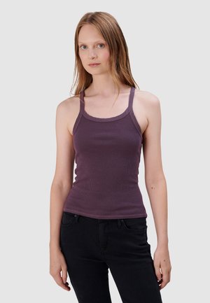 Paarse geribde tanktop met een ronde halslijn, dunne bandjes en een aangesloten ontwerp, gecombineerd met zwarte jeans.