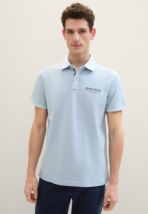 Lyseblå polo-shirt lavet af blødt bomuld med krave i hvidt, tre-knaps placket og broderet logo på venstre bryst.