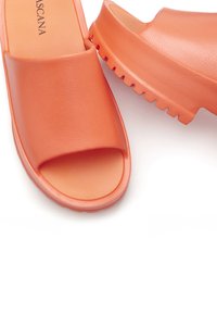 Oranje instapsandalen met een gestructureerde bovenkant en open teen ontwerp. De zool heeft een stevige, gekartelde patroontje voor grip.