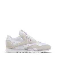 Valged ja beežid Reeboki sneakersuud koos sametiste ülekatetega, paeltega kinnitamise süsteem ja kummist tald, näidatud külgprofiilis valgel taustal.