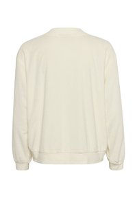 Felpa color crema con scollo rotondo, maniche lunghe e polsini a costine. Tessuto morbido con una vestibilità rilassata e un orlo arricciato.