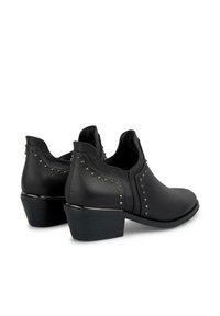 Bottines noires à finition en cuir lisse, à bout rond, avec un petit talon empilé et des clous en argent décoratifs le long des coutures latérales.