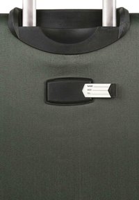 Maleta verde con ruedas, superficie texturizada, asa retráctil y un portatarjetas negro con una etiqueta de nombre.