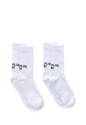 Deux paires de chaussettes blanches type crew avec un texte noir "PLJRI 87" affiché sur la partie supérieure sur fond blanc.