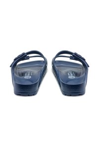 Kék műanyag szandálok virágmintájú díszítéssel a pánton, strukturált talpbetéttel és strapabíró, tapadásos talppal rendelkeznek.