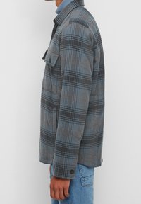 Camicia flanella a quadri grigia e blu, con colletto button-down, tasca frontale e maniche lunghe, tessuto texturizzato, vestibilità standard e polsini con bottone.