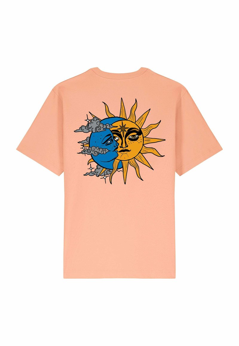 T-shirt en coton pêche présentant un design graphique d'un soleil et d'une lune divisés, avec des couleurs bleues et jaunes, des traits de visage détaillés et des nuages.