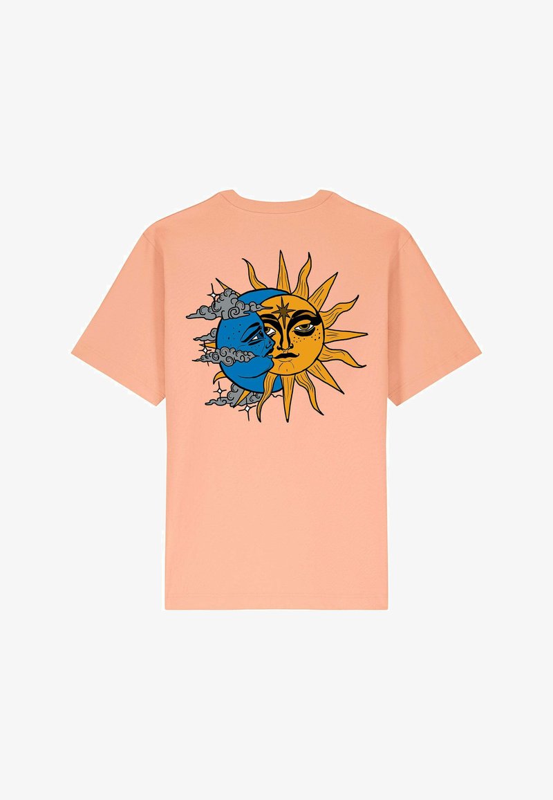 T-shirt in cotone pesca con un design grafico che rappresenta un sole e una luna divisi, con colori blu e giallo, dettagliate caratteristiche facciali e nuvole.