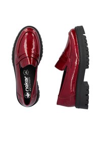 Mocassins en cuir verni rouge avec un bout rond, semelle en caoutchouc et détails texturés. Présentent une sangle sur le cou-de-pied et une semelle intérieure rembourrée.