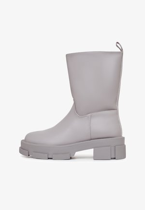 Grijze faux leren kniehoog laars met een ronde neus, dikke plateauzool en textuuraccenten. Voorzien van een trekhaak voor gemakkelijke aan- en uittrekken.
