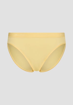 Gelbe nahtlose Unterwäsche im Bikini-Stil aus glattem Stoff mit elastischem Bund vor hellem grauem Hintergrund.