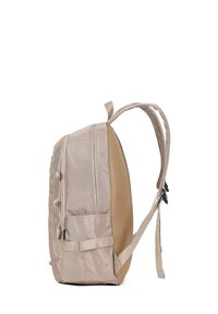 Beige rugzak met een textuur-mesh zijkant, twee voor-zippers en gevoerde schouderbanden. Vierkante vorm met een stevige basis en subtiele hardware-accenten.