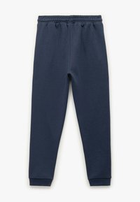 Navy bløde sweatpants lavet af en blød bomuldsblanding med elastisk talje og tapered cuffs ved anklerne. Glat tekstur, uden mønstre.