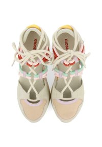 Zapatillas deportivas con parte superior de ante y malla en color beige, cordones elásticos coloridos en rosa, rojo y verde, con un diseño de punta dividida y acentos de múltiples texturas.