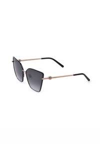 Lunettes de soleil avec verres dégradés noirs de forme carrée, monture fine en métal doré et extrémités de branches noires, inclinées sur fond blanc.