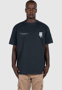 Dark navy short-sleeve t-shirt made of cotton with a relaxed fit. Features white graphic text on the front and a simple crew neckline.
