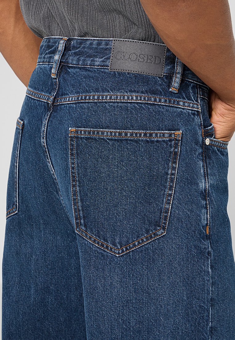 Dunkelblaue Jeans im geraden Schnitt, mit einem Leder-Logo-Patch, kontrastierenden Nähten und zwei Gesäßtaschen.