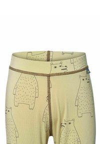 Helle beigefarbene Leggings mit einem schwarzen Bärenmuster, kontrastierender brauner Naht und einem kleinen blauen Etikett am Bund.