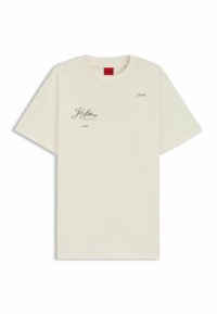 Cremefarvet bomulds t-shirt med korte ærmer. Har trykt tekst og grafiske accenter i sort. Rund halsudskæring, afslappet pasform.
