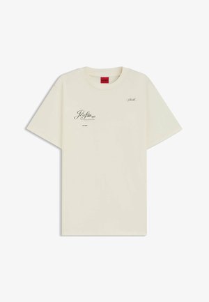 Cremefarvet bomulds t-shirt med korte ærmer. Har trykt tekst og grafiske accenter i sort. Rund halsudskæring, afslappet pasform.