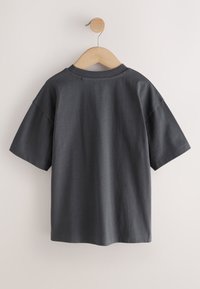Dark gray short-sleeve cotton t-shirt hanging on a wooden hanger against a plain white background.