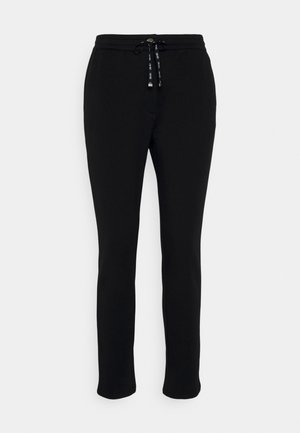 Czarne dresy z miękkiego materiału, z elastycznym paskiem w talii, zwężającymi się nogawkami oraz bez widocznych wzorów czy logo.