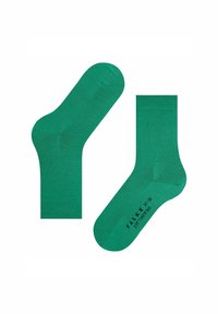Un paio di calzini verdi a metà polpaccio con polsini a coste, un calzino rivolto verso l'alto, l'altro che mostra un testo nero sulla soletta che recita "FALKE SOFTMERINO 37-38."