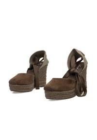 Zapatos de cuña de ante marrón con suela de yute trenzado, diseño cerrado en la punta y correas de tela ajustables, con un tacón alto y un envoltura texturizada en el tobillo.