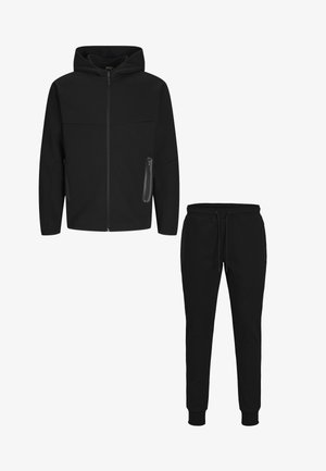 Ensemble de survêtement noir en deux pièces comprenant une veste à capuche zippée et un pantalon de jogging à taille élastique avec cordons de serrage et poches zippées.
