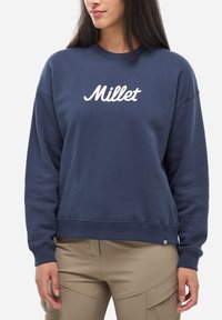 Sweatshirt bleu marine en coton, avec un col rond et des poignets côtelés. "Millet" brodé en blanc sur la poitrine.