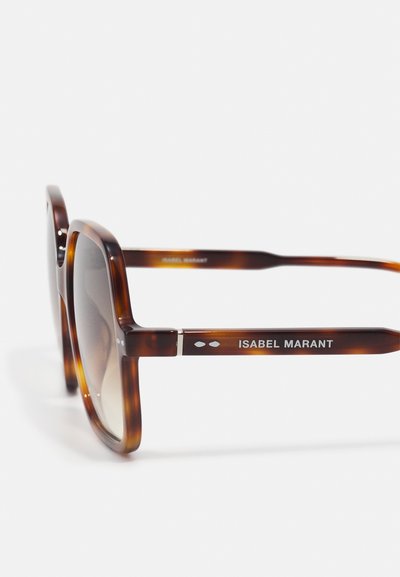 Lunettes de soleil carrées écaille avec verres dégradés et logo "ISABEL MARANT" sur la branche sur fond blanc.
