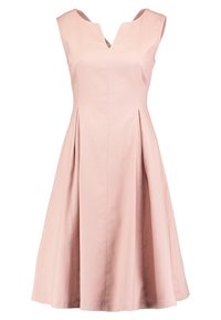 Robe rose texturée sans manches longueur genou, avec un décolleté en V et des plis le long de la jupe pour plus de volume.