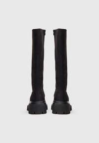 Μαύρες σουέντ μπότες μέχρι το γόνατο με ευθύ σχεδιασμό, πλευρικά φερμουάρ και υφασμένα λαστιχένια παπούτσια με βαθιές αυλακώσεις για καλύτερη πρόσφυση.