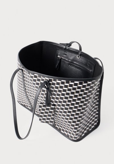 Sort og hvid geometrisk mønstret tote taske med en robust struktur, læderdetaljer, en lynlås-lomme og lange remme for nem bæring.