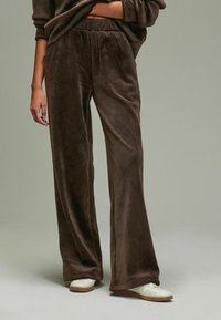 Bruine, luxe, wijde broek met een zachte textuur, voorzien van een hoge elastische tailleband en subtiele plooien aan de voorkant.