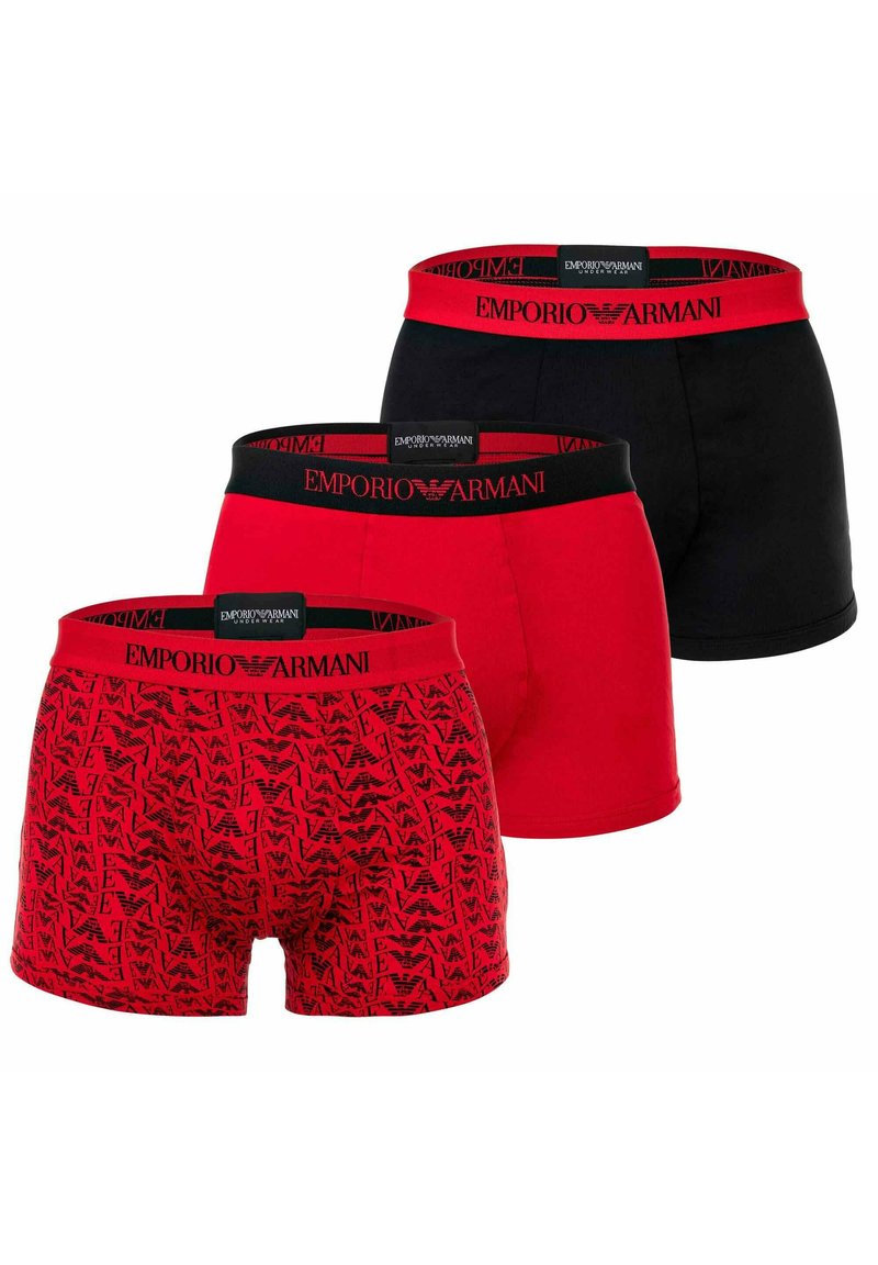 Trois paires de boxers Emporio Armani : un noir, deux rouges avec des motifs différents, dotés de ceintures élastiques avec des accents de logo.