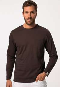 Brown langemouwen shirt met een ronde halslijn, voorzien van een borstzak, gemaakt van zachte stof met een subtiele textuur en labeldetail op de mouw.