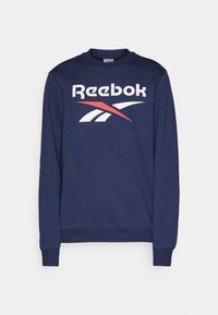 Mornarska dukserica izrađena od pamučne mješavine, s okruglim izrezom i rebrastim manžetama, s velikim Reebok logotipom u bijeloj i crvenoj boji.