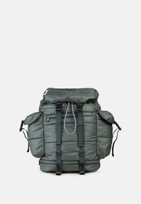 Gepolsterter grauer Rucksack mit Rollverschluss, verstellbaren Trägern, zwei Seitentaschen und reflektierendem Kordelakzent. Hat eine strukturierte Oberfläche.