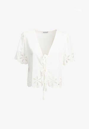 Witte blouse met korte mouwen, met bloemmotieven in ajour op de mouwen en zoom, veter aan de voorkant en gegolfde randen.