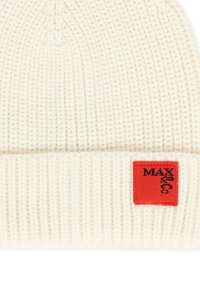 Beanie bianco lavorato a maglia con texture a coste, dotato di un'etichetta quadrata rossa con testo nero fissata al risvolto. Design semplice e funzionale.