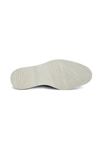 Suela de zapato negra con una base de goma blanca texturizada, que presenta surcos y un patrón triangular para mayor agarre. Marca grabada en el lateral.
