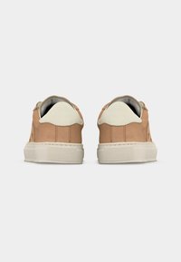 Ζευγάρι ταμπά αθλητικά παπούτσια με λευκά μπροστινά μέρη και παχιά λευκή σόλα, σε θέα από πίσω πάνω σε απλό ανοιχτό φόντο.