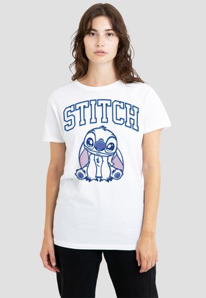 White cotton T-shirt featuring a graphic of Stitch with large eyes and pink accents. "STITCH" printed in blue above the character. Short sleeves.