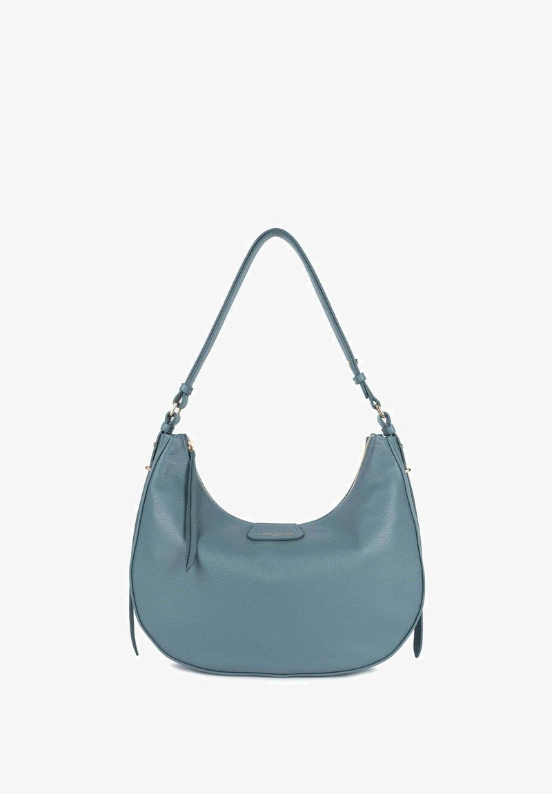 Leren schoudertas in een gedempte teal kleur, met een gebogen vorm, enkele schouderriem, ritsluiting en een klein logo op de voorkant.