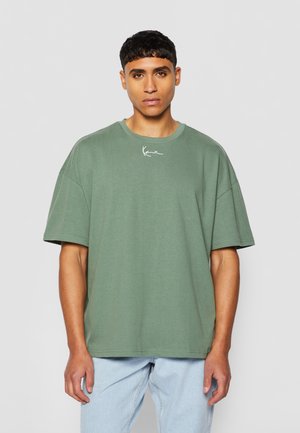Green oversized cotton t-shirt with short sleeves, featuring a round neckline and a white embroidered logo on the chest.