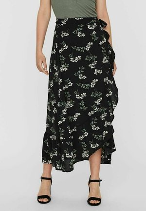 Sort blomsterindpakket nederdel med hvide blomster og grønne blade, flæsekant, lavet af let stof, bundet i taljen.