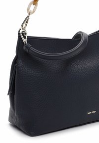 Granatowa skórzana torba z fakturowanym wykończeniem, wyposażona w zaokrąglony uchwyt oraz odpinany łańcuch jako ozdobę. Delikatne logo przy podstawie.