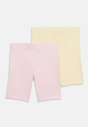 To par med enkle, knelange shorts i pastellrosa og blekgul, brettet og lagt flatt på en hvit bakgrunn.